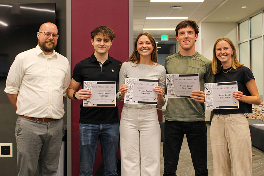 Five individuals proudly display their certificates in a modern office setting